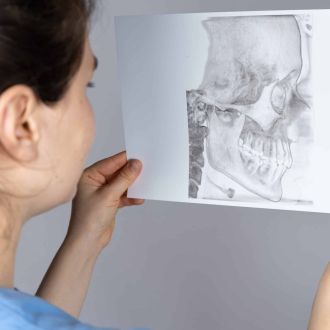 Mitarbeiterin hält Scan des Kiefergelenks vor sich