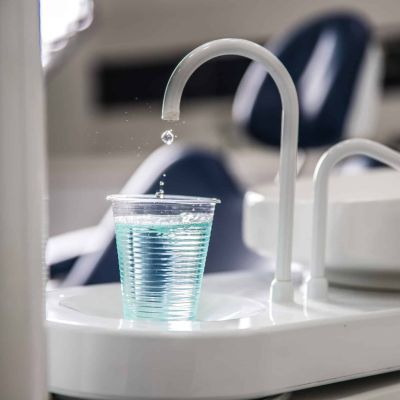 Wasserhahn neben dem Behandlungsstuhl mit Becher