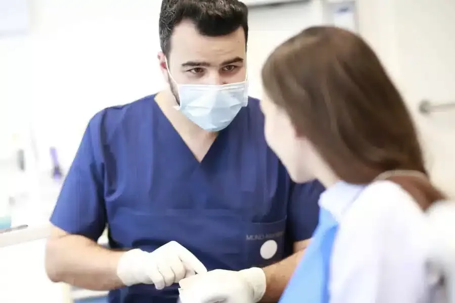 Zahnarzt Hannover: Sami Atassi erklärt einer Patientin eine Behandlung am Zahnmodell